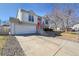 Charming two-story home features a bright red front door and attached two-car garage at 11278 W 103Rd Dr, Broomfield, CO 80021