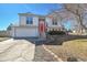 Charming two-story home features a bright red front door and attached two-car garage at 11278 W 103Rd Dr, Broomfield, CO 80021