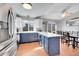 Modern kitchen boasts an island with blue cabinets and stainless steel appliances adjacent to the dining area at 11278 W 103Rd Dr, Broomfield, CO 80021