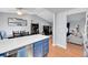 Open concept kitchen and dining area with blue island, wood floors, and access to the living room at 11278 W 103Rd Dr, Broomfield, CO 80021