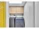 Laundry room with modern washer and dryer and wooden cabinets at 11278 W 103Rd Dr, Broomfield, CO 80021