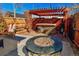 Backyard with stone fire pit, wooden pergola, and outdoor bar with seating at 1322 N Kalamath St, Denver, CO 80204