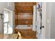 Bathroom featuring a bathtub with decorative brown tile surround, white shower curtain, and natural light at 1322 N Kalamath St, Denver, CO 80204