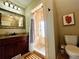 Nicely tiled bathroom featuring a shower with a decorative tile surround, vanity, and a toilet at 1322 N Kalamath St, Denver, CO 80204