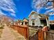 Charming gray home featuring well-maintained exteriors, a lovely wooden fence, and a vibrant blue sky at 1322 N Kalamath St, Denver, CO 80204