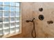 Tiled shower featuring glass block window and bronze shower head at 1322 Kalamath St, Denver, CO 80204