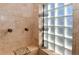 Tiled shower featuring glass block window and bronze fixtures at 1322 Kalamath St, Denver, CO 80204