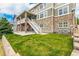 Large backyard with a covered patio, stairs to the second floor deck, and a green lawn at 5010 Persimmon Ln, Castle Rock, CO 80109