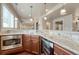 Basement bar with granite countertops, stainless steel appliances, wood cabinets and modern pendant lighting at 5010 Persimmon Ln, Castle Rock, CO 80109