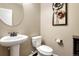 Powder room with pedestal sink, decorative mirror and lighting, and tiled floors at 5010 Persimmon Ln, Castle Rock, CO 80109