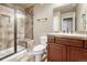 Bright bathroom featuring a glass enclosed shower with bench and a vanity with granite countertops and dark wood cabinets at 5010 Persimmon Ln, Castle Rock, CO 80109