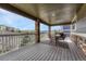 Inviting covered deck with brick columns, outdoor seating, and views of the neighborhood at 5010 Persimmon Ln, Castle Rock, CO 80109