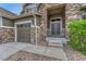 Inviting front porch with stone accents, double doors and cozy seating area with rocking chairs at 5010 Persimmon Ln, Castle Rock, CO 80109