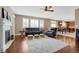 Bright, open-concept living room with hardwood floors, fireplace, and comfortable leather furniture at 5010 Persimmon Ln, Castle Rock, CO 80109