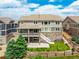 Rear view of a home with a covered patio, second story deck, stone accents, and well-kept landscaping at 5010 Persimmon Ln, Castle Rock, CO 80109