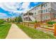 A long sidewalk along a fenced yard, leading to a grassy, common green space in the neighborhood at 5010 Persimmon Ln, Castle Rock, CO 80109