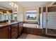 Bright bathroom featuring a soaking tub, shower, and vanity with granite counters at 11945 S Saunter Ln, Parker, CO 80138