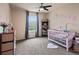 This bedroom boasts a ceiling fan, a large window and pink decor at 11945 S Saunter Ln, Parker, CO 80138