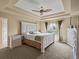 Spacious main bedroom with tray ceiling, fan, and bright natural light at 11945 S Saunter Ln, Parker, CO 80138