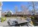 Backyard with well-kept green grass, tall trees and a patio set with four chairs at 8441 Urban Ct, Arvada, CO 80005