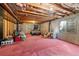 Unfinished basement with exposed wood ceiling and support beams, a bed and small window at 8441 Urban Ct, Arvada, CO 80005