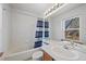 Well-lit bathroom with vanity, white tiling, shower-tub combo and natural light at 8441 Urban Ct, Arvada, CO 80005
