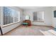 Light-filled bedroom featuring a vanity with a round mirror, and two large windows at 8441 Urban Ct, Arvada, CO 80005