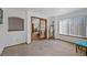 Bright living room featuring a wooden door, large windows and neutral carpet at 8441 Urban Ct, Arvada, CO 80005