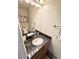 Well-lit bathroom with a marble countertop vanity, a mirror and a decorative flower artwork on the wall at 8769 S Dudley St, Littleton, CO 80128