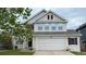 Charming two-story home features an attached two car garage, manicured lawn, and decorative shutters at 8769 S Dudley St, Littleton, CO 80128