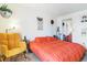 Bedroom with a large bed, yellow chair, and wall hanging at 10150 E Virginia Ave # 19-303, Denver, CO 80247