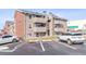 Multi-Gathering home featuring private balconies, assigned parking, and a mix of brick and wood siding at 10150 E Virginia Ave # 19-303, Denver, CO 80247
