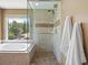 Bathroom features a glass enclosed shower and soaking tub with a window overlooking the yard at 3043 W 109Th Pl, Westminster, CO 80031