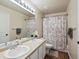 Bright bathroom features a double sink vanity and a shower/tub combo with decorative floral curtain at 3043 W 109Th Pl, Westminster, CO 80031