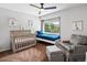 Sweet bedroom offers a crib and daybed by a bright window with treetop views at 3043 W 109Th Pl, Westminster, CO 80031
