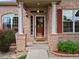Charming brick home entrance with red shutters, white columns, and a well-maintained walkway at 3043 W 109Th Pl, Westminster, CO 80031