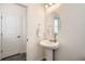 Charming powder bath features pedestal sink, oval mirror, and luxury vinyl plank flooring at 4903 Basalt Ridge Cir, Castle Rock, CO 80108