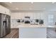 Bright kitchen features white cabinets, stainless steel appliances, and a large center island with quartz countertop at 4903 Basalt Ridge Cir, Castle Rock, CO 80108