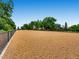 Large fenced in area filled with tan mulch and bordered by mature shade trees, perfect for an off leash dog park at 3304 W 3Rd Ave, Denver, CO 80219
