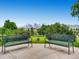 Two iron park benches overlook lush green grass and mature trees with a distant downtown city skyline at 3304 W 3Rd Ave, Denver, CO 80219