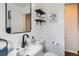 Bathroom with a white sink, toilet, black shelves, and a fun animal picture at 5295 Perry St, Denver, CO 80212