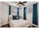Cozy bedroom with a ceiling fan, bright teal curtains and two windows at 5295 Perry St, Denver, CO 80212
