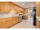 Bright kitchen with light wood cabinets, stainless steel appliances, and tile flooring at 511 Plateau Pkwy, Golden, CO 80403