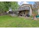 Backyard with grassy lawn, wooden deck and fence, with a two-story home in the background at 12466 E Amherst Cir, Aurora, CO 80014