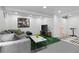 Basement space with modern sectional sofa, faux grass rug, art and recessed lighting at 12466 E Amherst Cir, Aurora, CO 80014