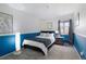 Comfortable bedroom featuring a soft bed, gray carpet, blue accent paint and natural light from a window at 12466 E Amherst Cir, Aurora, CO 80014