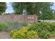 Community entrance with a brick sign, lush landscaping, and a well-maintained street at 12466 E Amherst Cir, Aurora, CO 80014