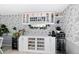 Kitchen wine bar featuring custom cabinetry, wine racks, wine fridge, and ample countertop space at 12466 E Amherst Cir, Aurora, CO 80014