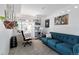 Bright living room with a blue sofa, desk, plants, decorations and carpet at 12466 E Amherst Cir, Aurora, CO 80014