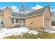 Charming tan home featuring an attached garage and a cozy front entrance with white door and window trim at 13040 W 63Rd Pl # A, Arvada, CO 80004